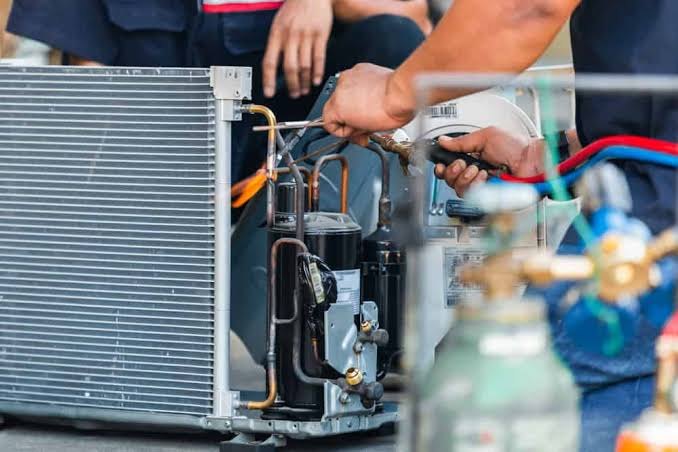 Close-up of HVAC compressor and copper lines during a repair